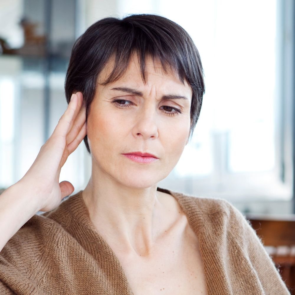 Person experiencing sound sensitivity and discomfort from everyday sounds.