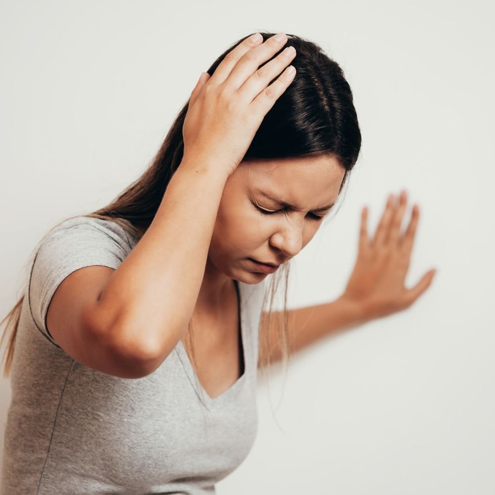 Woman experiencing dizziness and balance difficulties associated with vertigo.